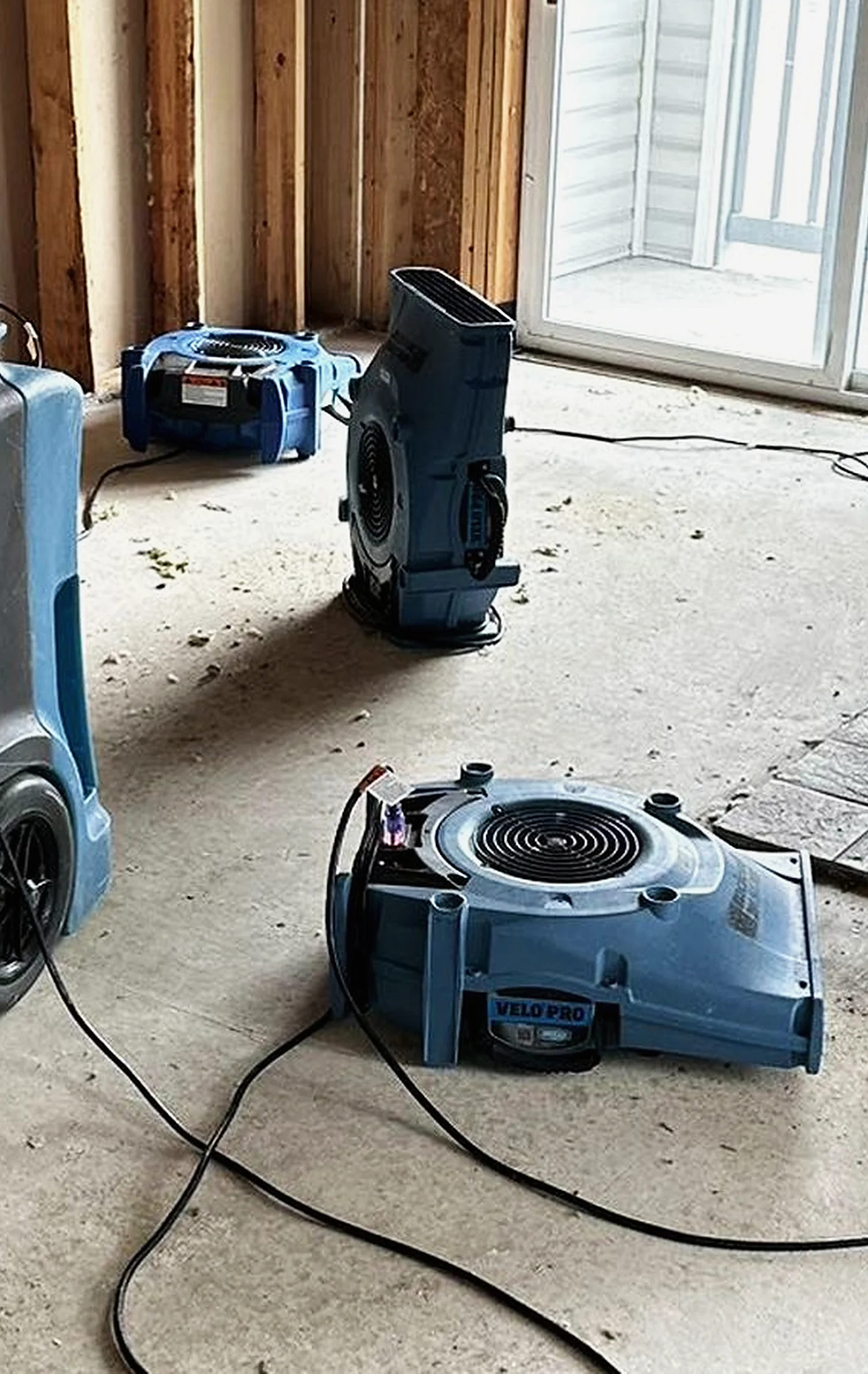 Air movers drying a stripped room on a live restoration job site.